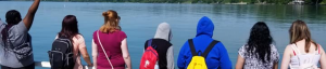 students standing and admiring a body of water
